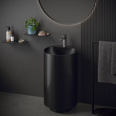 a bathroom with a round mirror above the sink and towel rack in front of it