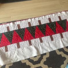 a table runner with red and black trees on it