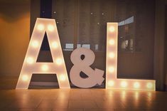 light up letters spelling out the word love in front of a wall with lights on it