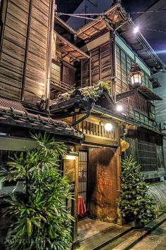 an old wooden house is lit up at night