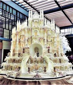 a large white cake is on display in a building