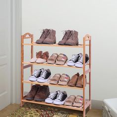 several pairs of shoes are on a wooden shelf in front of a door and rug