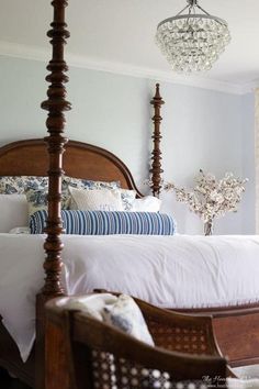 a bedroom with a four post bed and chandelier