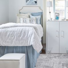 a bedroom with white furniture and blue accents