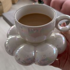 a person holding a cup of coffee in their hand