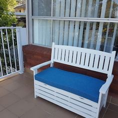 a white wooden bench sitting on top of a tiled floor next to a window with blinds