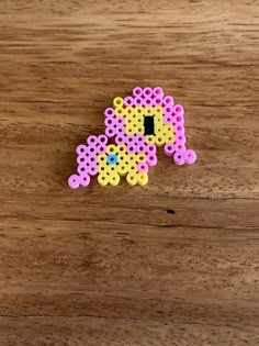 a piece of perler beads sitting on top of a wooden table