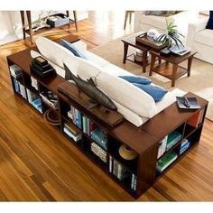 a living room filled with furniture and bookshelves on top of a hard wood floor