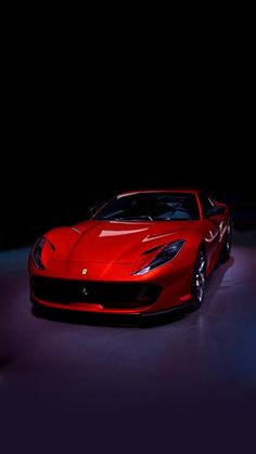 a red sports car is parked in the dark