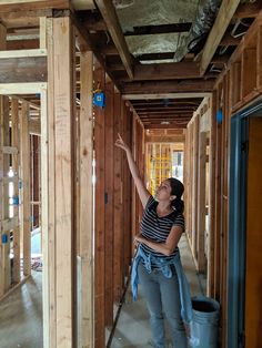 a woman standing in the middle of a room under construction