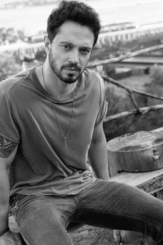 a man sitting on top of a wooden bench