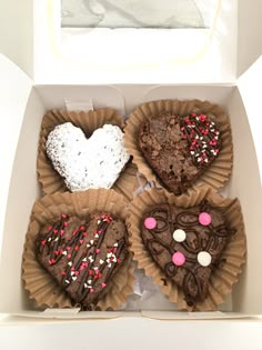 four heart shaped brownies in a box with sprinkles and hearts on them