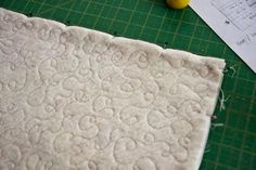 a piece of fabric sitting on top of a cutting board next to a rubber duck