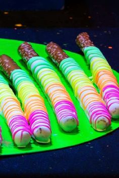 there are many colorful candy sticks on the green plate