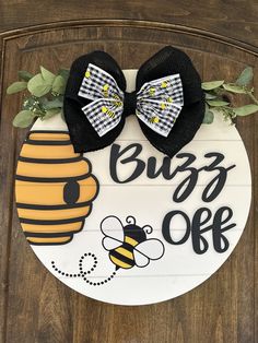 a door hanger with two bows and a bee on it