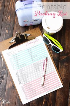 the printable packing list is sitting on top of a clipboard next to a blue suitcase