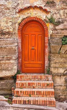 an orange door with brick steps leading up to it