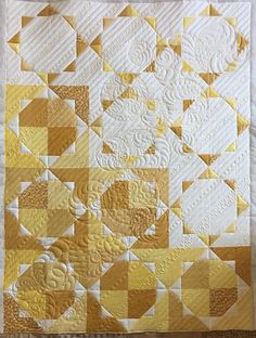 a yellow and white quilted wall hanging