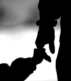 the silhouette of a person holding a teddy bear in their hand with another one's arm