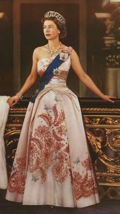 an old photo of a woman in a gown and tiara standing on a balcony