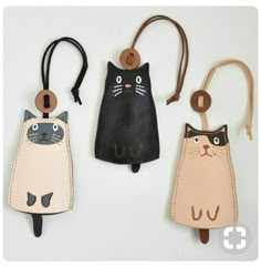 three leather key fobs with cats on them