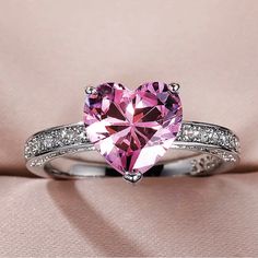 a pink heart shaped diamond ring with white diamonds