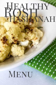 a white plate topped with cauliflower next to a green napkin