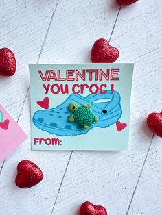 a valentine card with a turtle on it and hearts scattered around the postcard reads, valentine you croc from