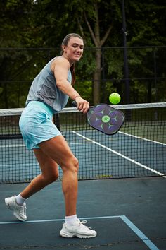 a female tennis player in action on the court with her racquet and ball