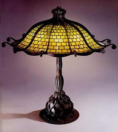 a lamp that is sitting on top of a table with a glass shade over it