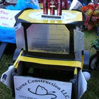 the construction inc sign is on display in front of some other signs and decorations at an outdoor event