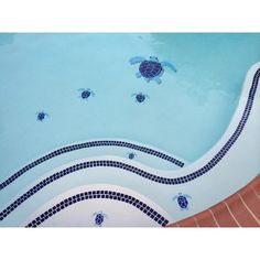 an empty swimming pool with blue tiles and turtles on the side, as well as steps leading up to it