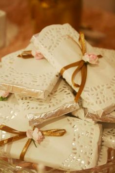 some white napkins wrapped in brown ribbon and flowers on a glass platter with pink roses