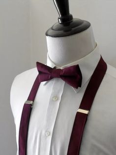 a mannequin wearing a white shirt with a red bow tie and suspenders