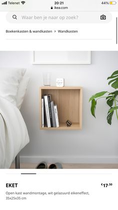 a shelf with books and other items on it next to a bed in a room