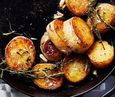 baked potatoes with rosemary sprigs in a cast iron skillet