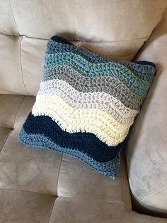 a crocheted pillow sitting on top of a couch