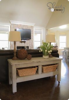 a living room filled with furniture and a flat screen tv on top of a wooden table