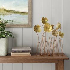 some plants are sitting on a shelf next to a painting