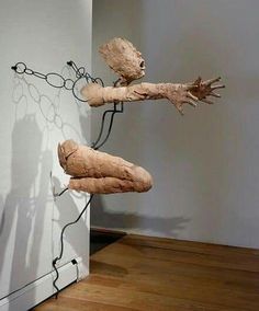 an art piece is hanging on the wall next to a wooden floor with chains attached to it