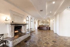 an empty room with a fireplace and chairs