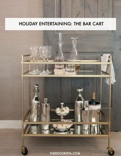 a gold bar cart filled with bottles and glasses