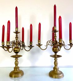 a group of brass candelabra with red candles