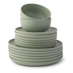 a stack of green bowls and plates stacked on top of each other