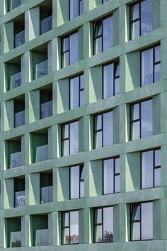 the side of a green building with many windows