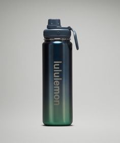 a blue and green water bottle sitting on top of a table