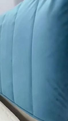 a close up of a bed with blue pillows