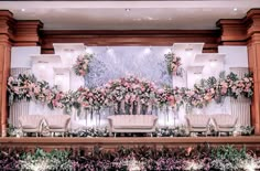 the floral wall is decorated with pink flowers and greenery for an elegant wedding reception