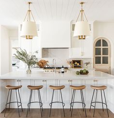 a kitchen island with four stools in front of it