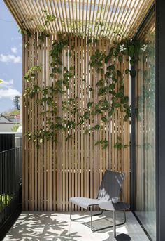 a chair sitting on top of a patio next to a wooden slatted wall